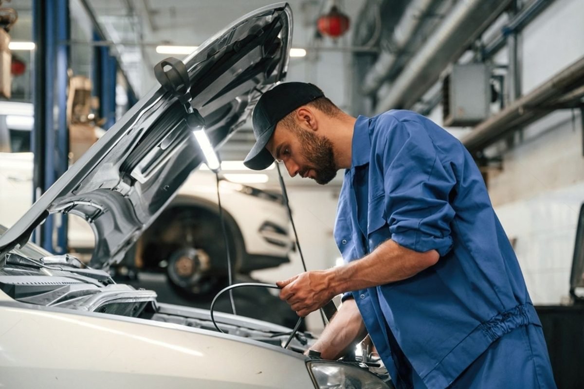 A mechanic checks a car engine in a workshop