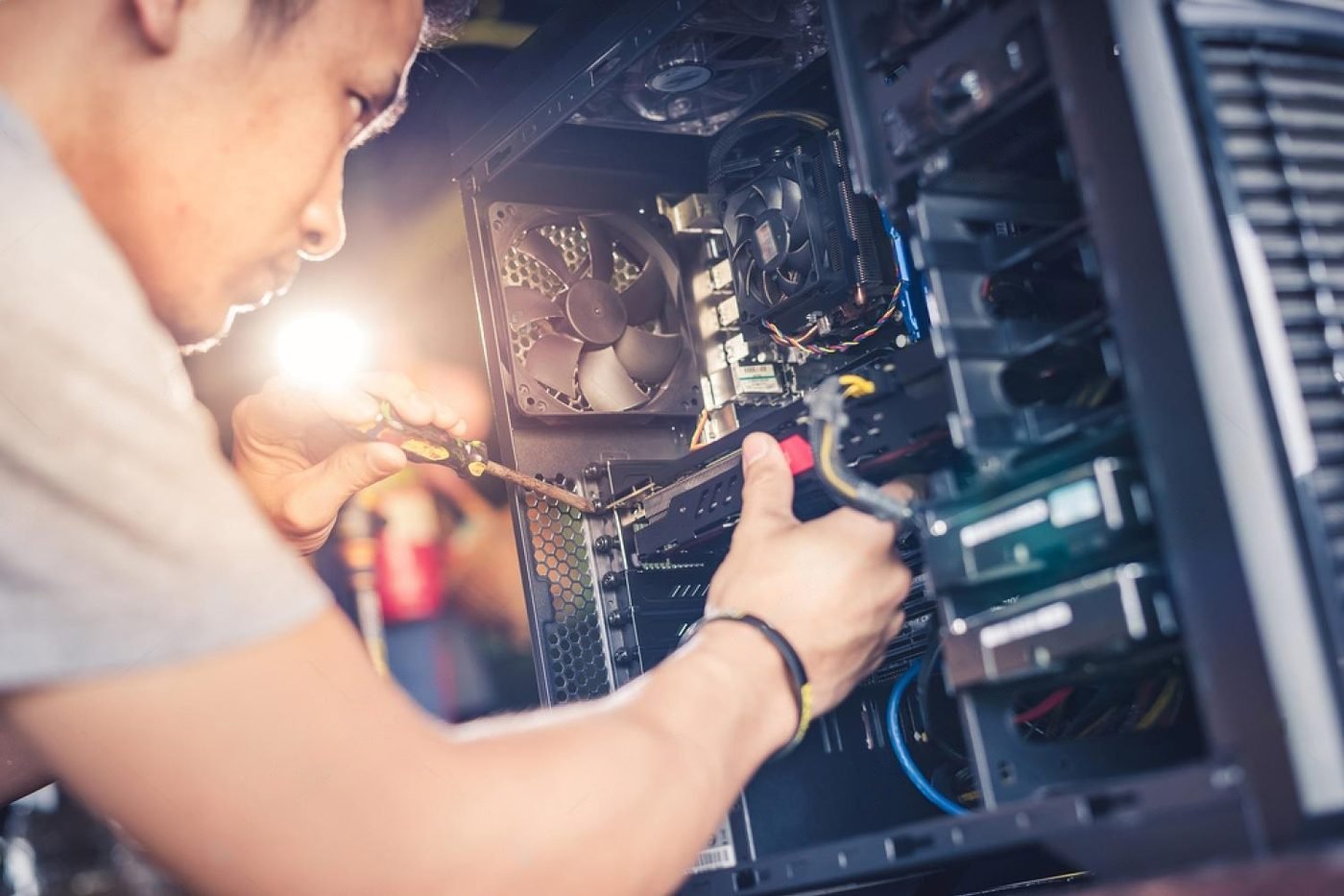 A technician repairing the inside of a computer