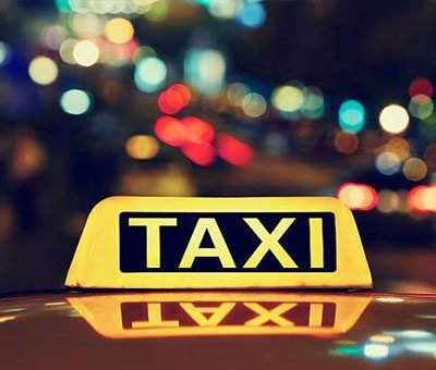 A lit taxi sign at night