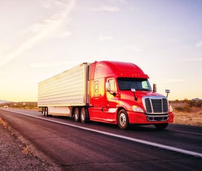 A red freight truck on an open road