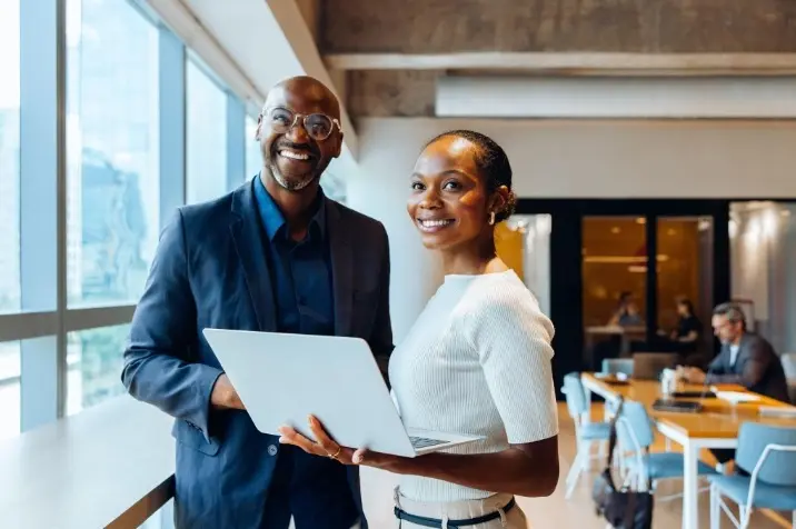 Two professionals working on a laptop